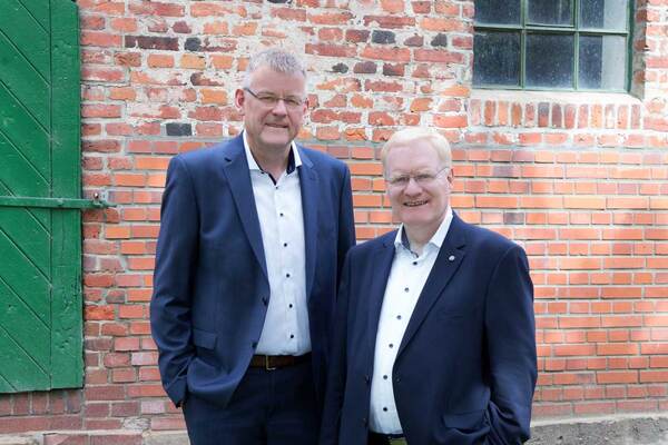 Andreas Pape und Axel Lohse vor einem Backsteingebäude
